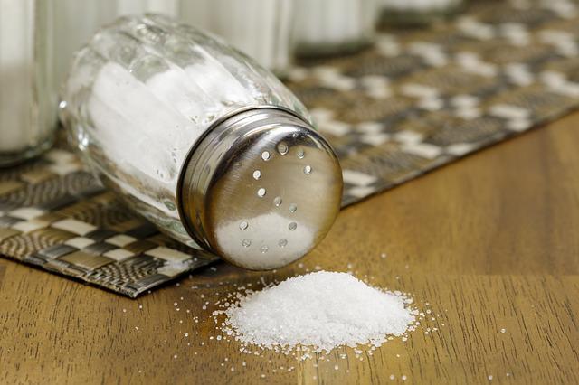 Salt shaker on table tipped over spilling salt