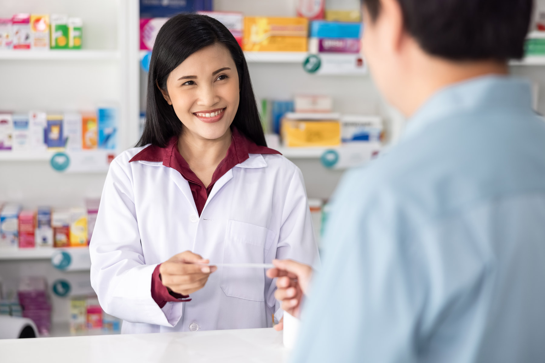 Female pharmacist taking prescription from male patient