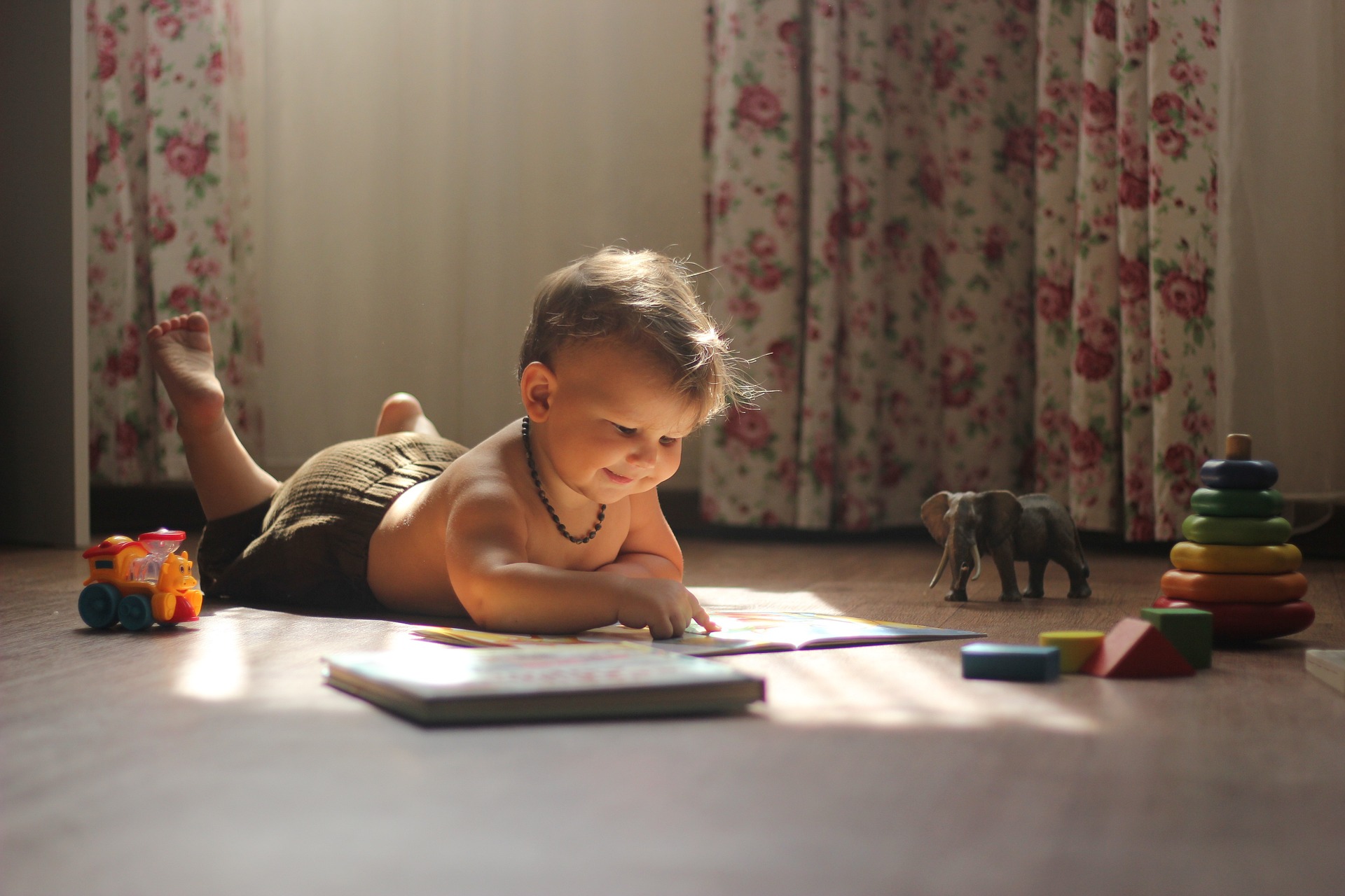 Baby lying on floor playing with blocks