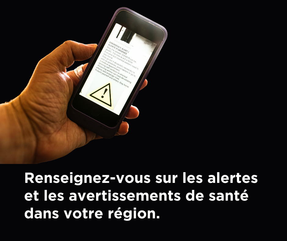 Closeup of hand holding mobile phone with an alert appearing on screen with caption "Reseignez-vous sur les alertes et les avertissements de sante dans votre region."