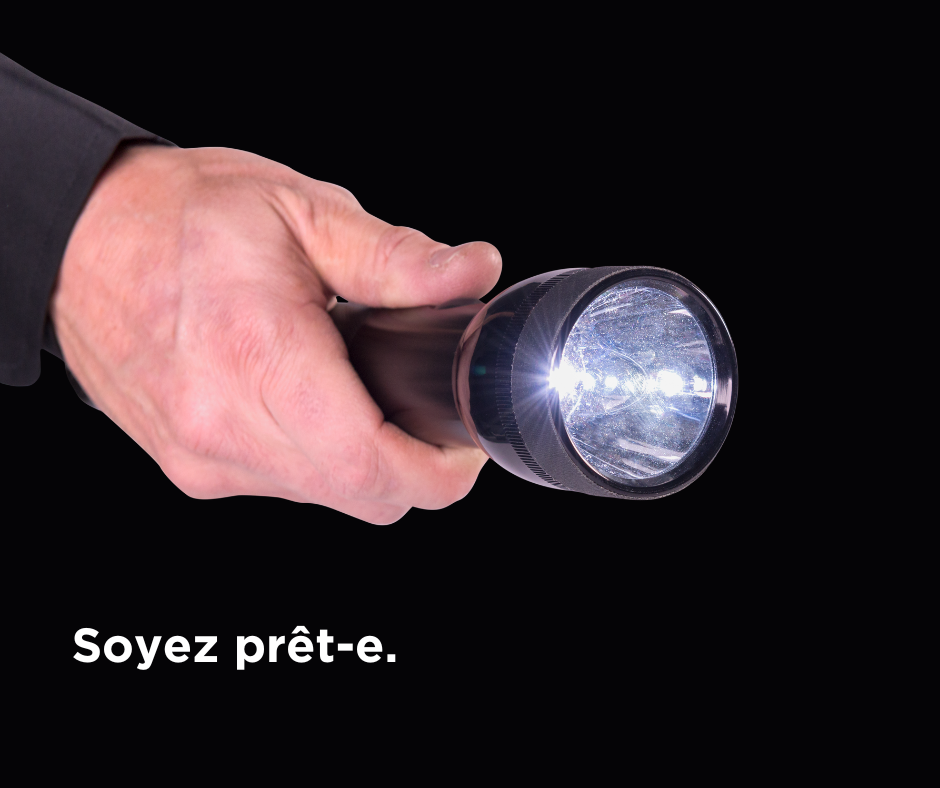 Closeup of male hand holding flashlight with caption "Soyez pret-e"
