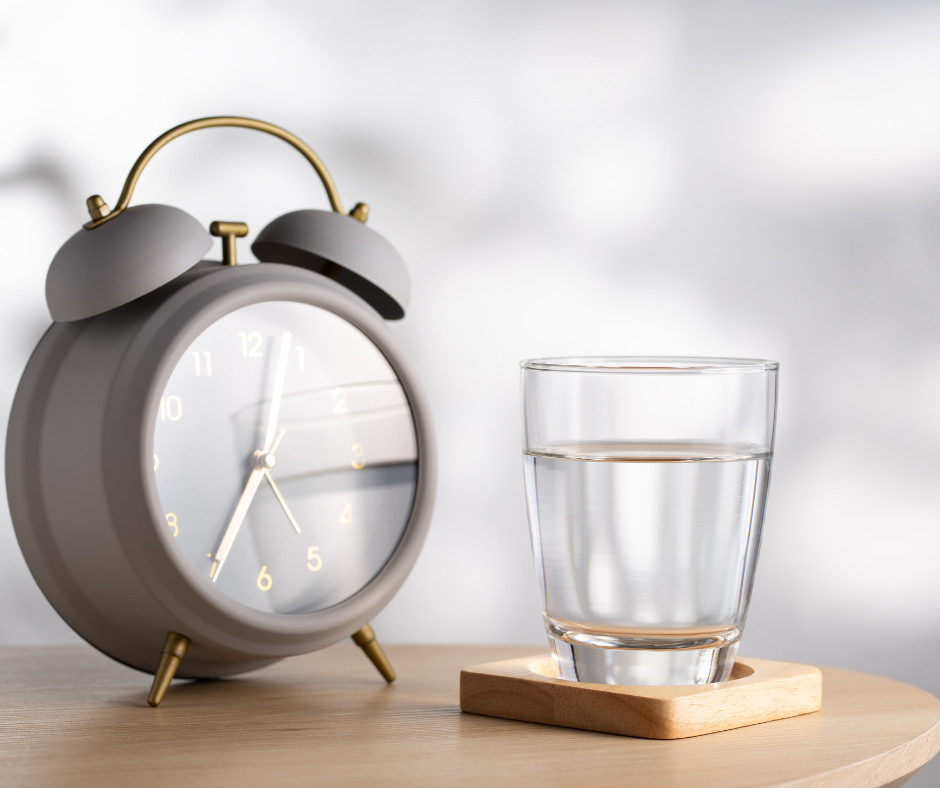 Alarm clock and glass of water to represent DELAY and DRINK WATER