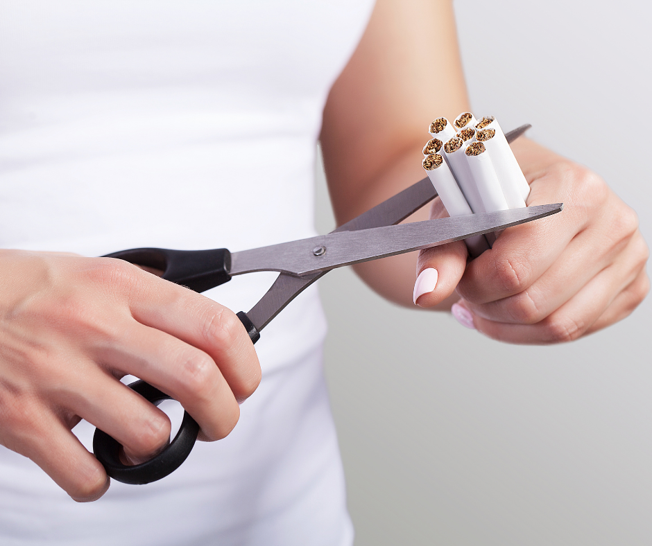 Woman using scissors to cut handful of cigarettes